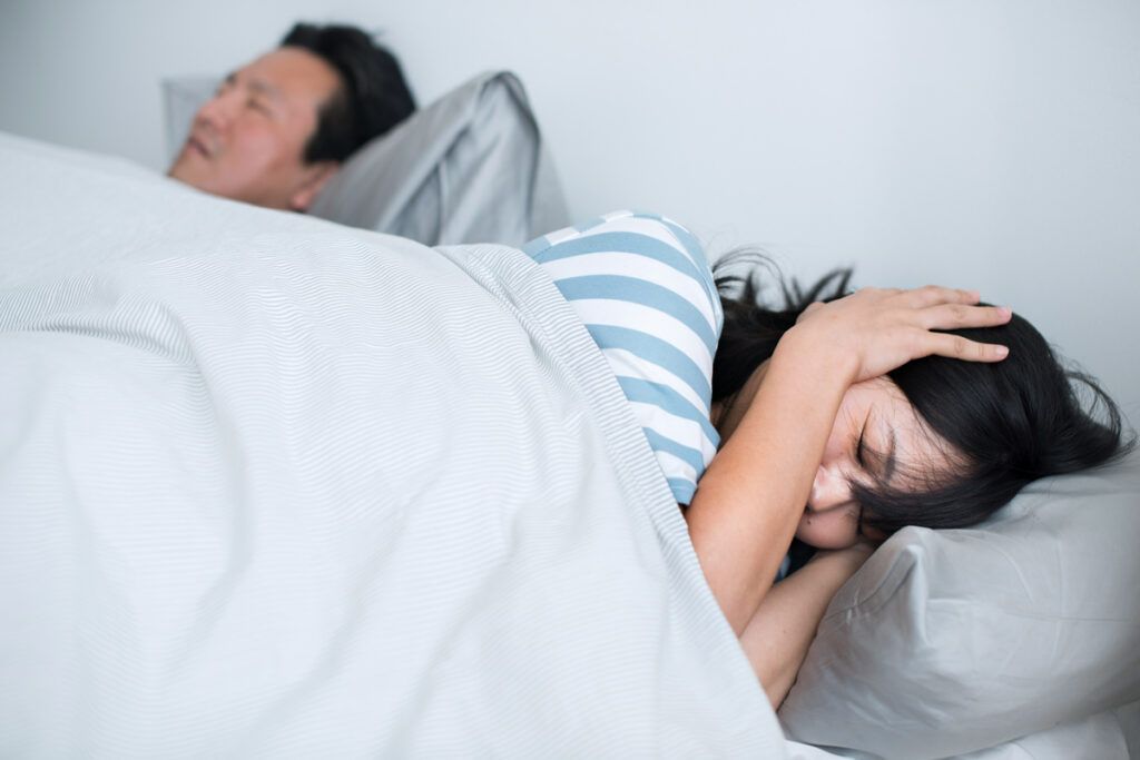 Person who can't sleep because their partner is snoring