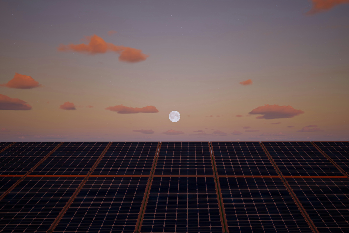 The moon over solar panels at dawn or dusk