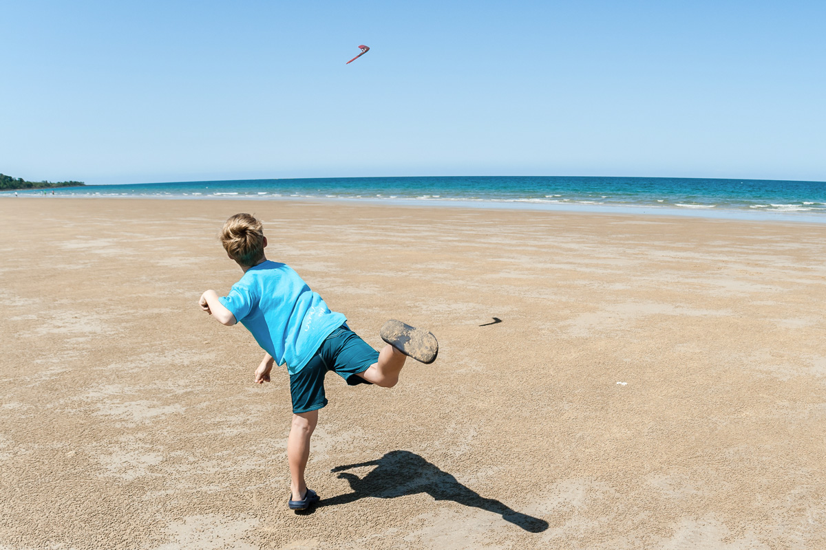 Kid throwing boomerang at the beach