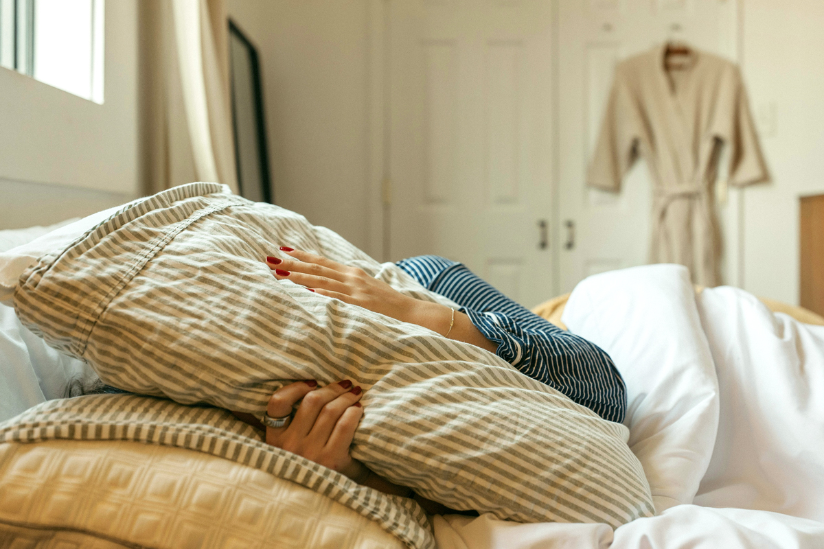 Person sleeping in bed during the morning