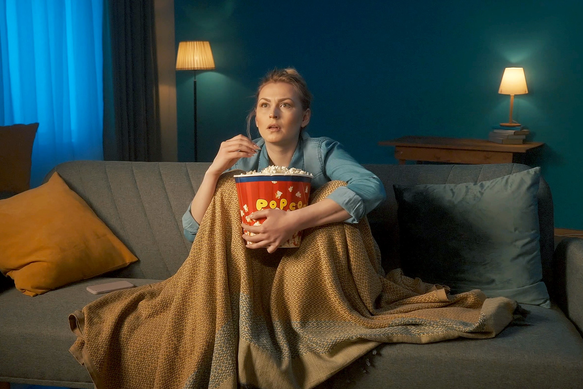 Person eating popcorn on the couch