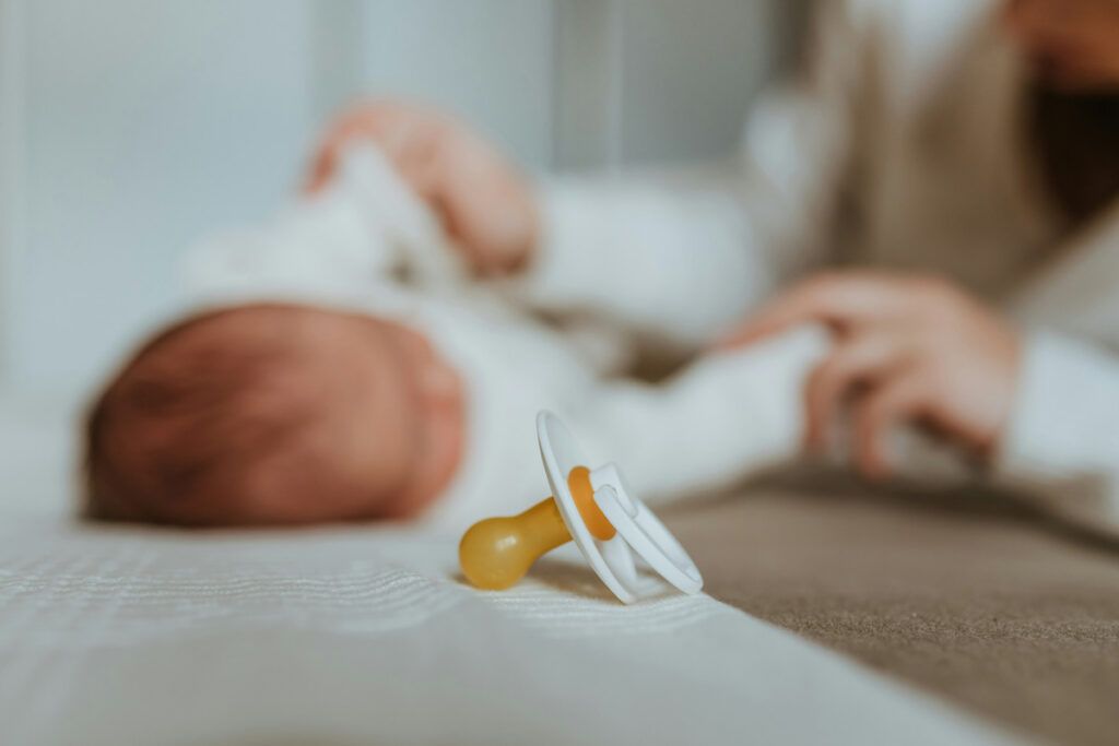Pacifier in foreground with baby in background