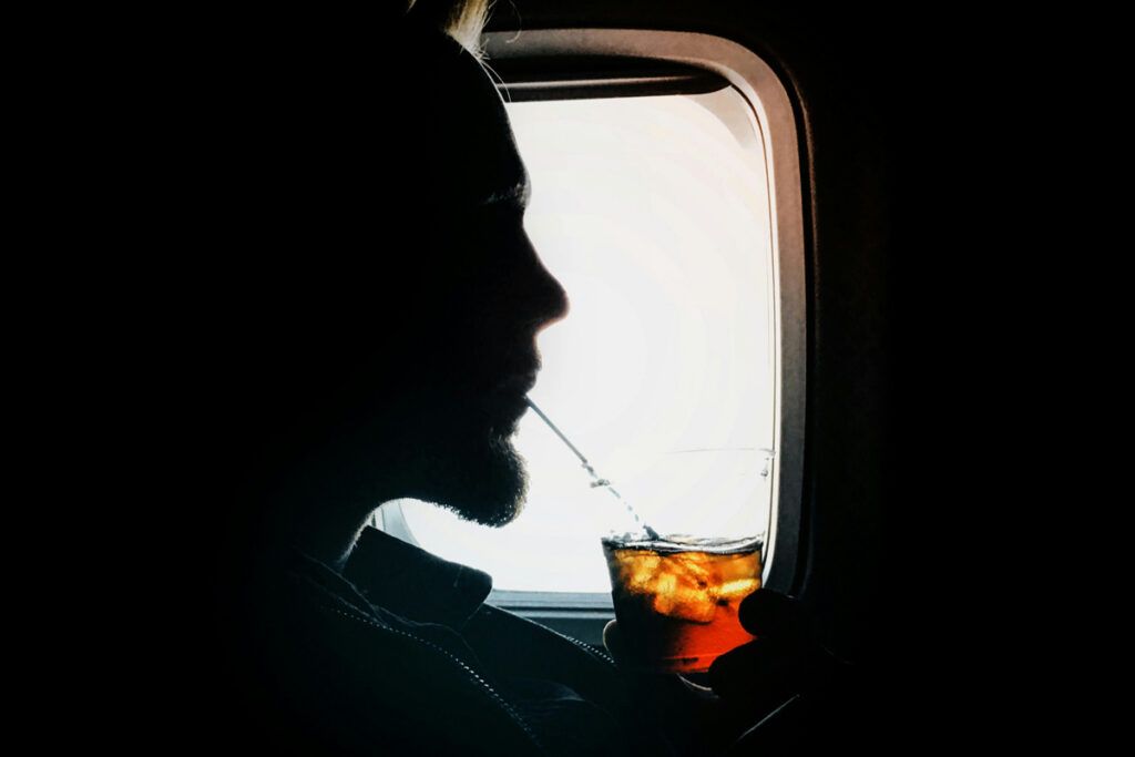 Airplane passenger sipping a drink