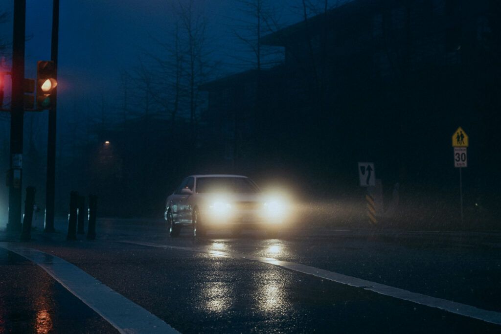 Car driving in the dark with headlights on
