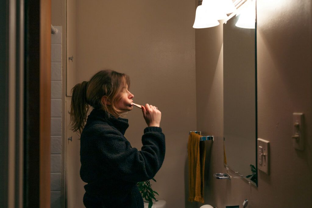 Person brushing theit teeth in the mirror
