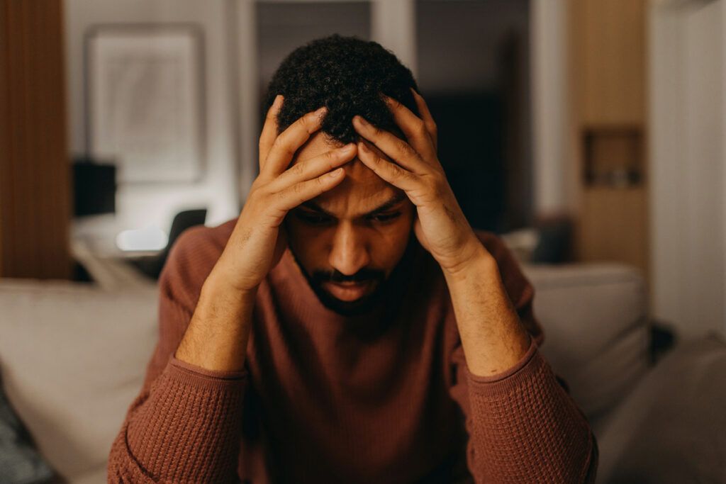 Stressed person with head in their hands