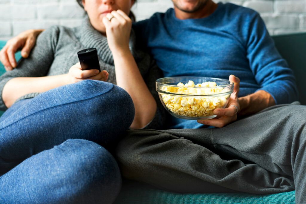 Couple eating popcorn on the sofa